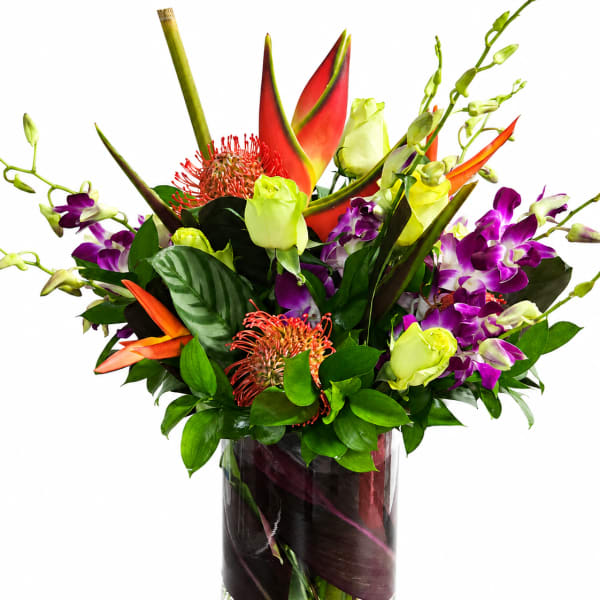 Tropical bouquet with purple orchids and red-orange heliconia in a glass vase