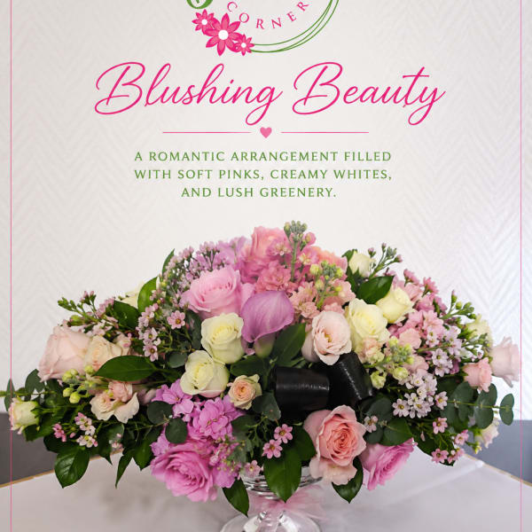 Pink and white floral arrangement in a clear pedestal vase
