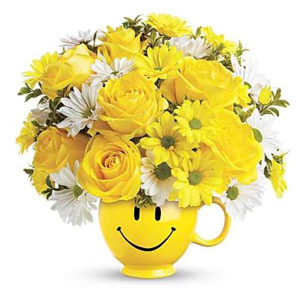 Yellow roses and white daisies in a smiley-face mug