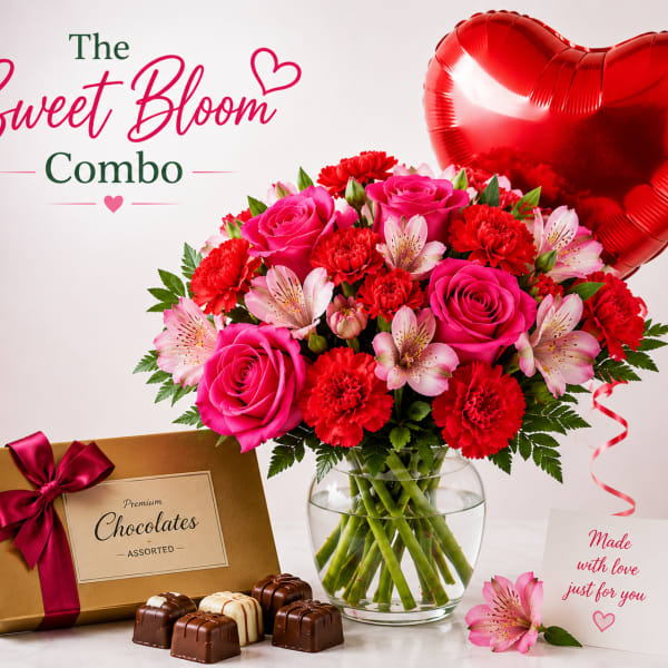 Pink and red flower bouquet in a glass vase with a heart balloon and chocolates