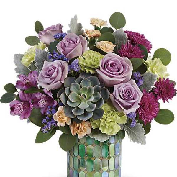 Compact arrangement of purple and peach flowers with a central succulent in a mosaic green cylinder vase