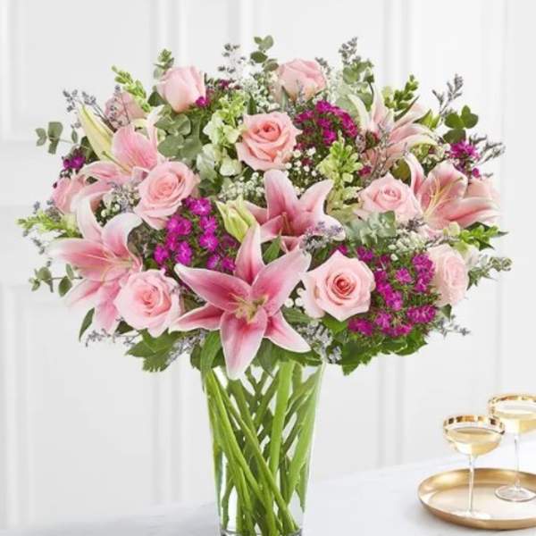 Pink lilies and roses in a clear glass vase
