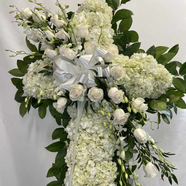 White floral standing spray with roses and hydrangeas on a ribboned easel