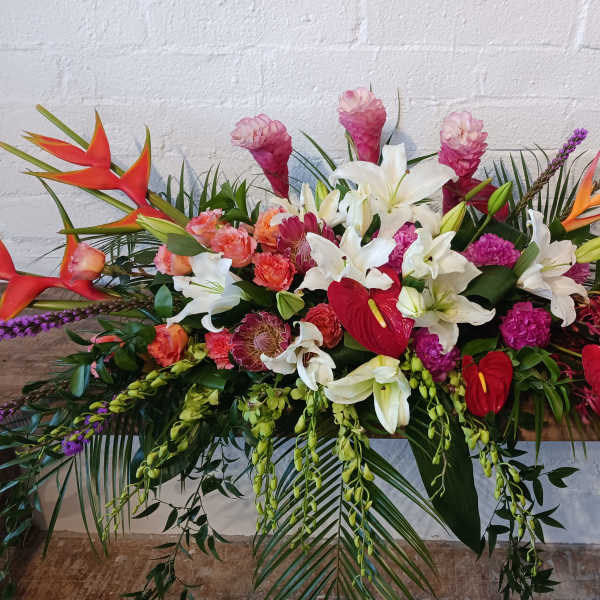Large tropical floral arrangement with white lilies and red anthuriums