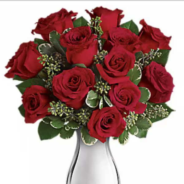 Red roses arranged in a clear glass vase