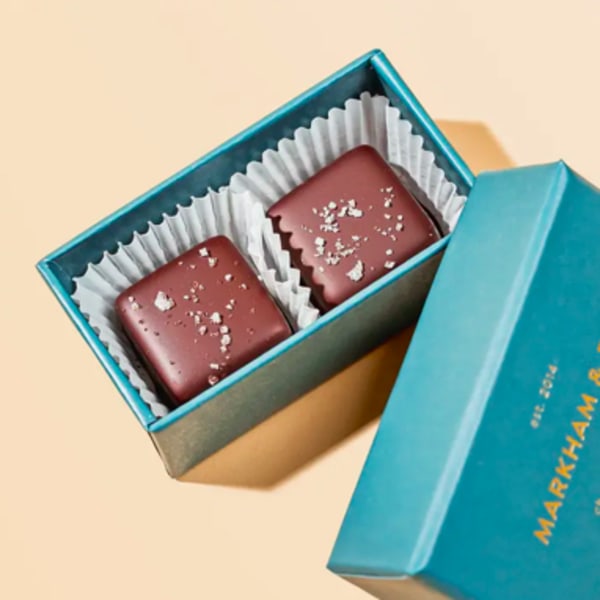 Two chocolate candies in a blue gift box with a lid
