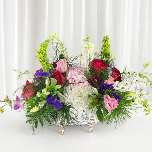 Large mixed floral arrangement in a decorative silver basket