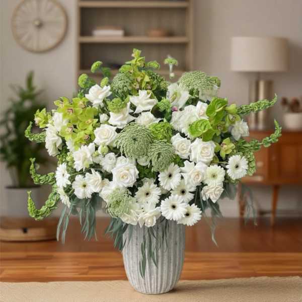 White and green floral arrangement in a ribbed vase