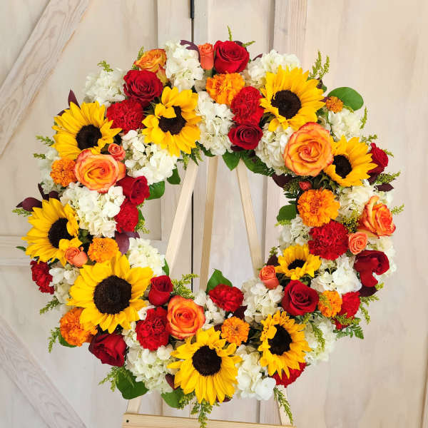 Heart-shaped floral wreath with sunflowers, roses, and white blooms