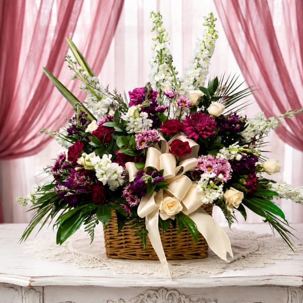 Basket arrangement of white and magenta flowers with a cream ribbon