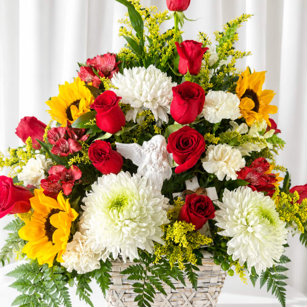 Basket arrangement of red roses, white chrysanthemums, and yellow sunflowers