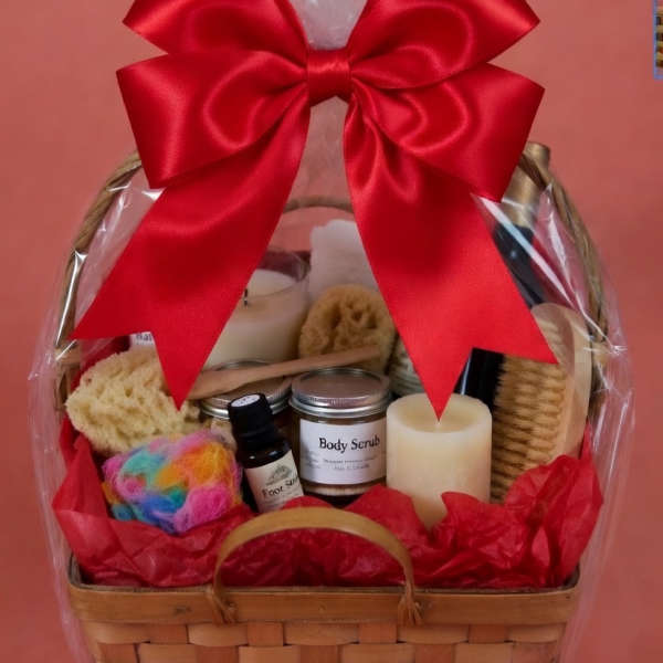 Gift basket with bath items, candles, and a large red bow
