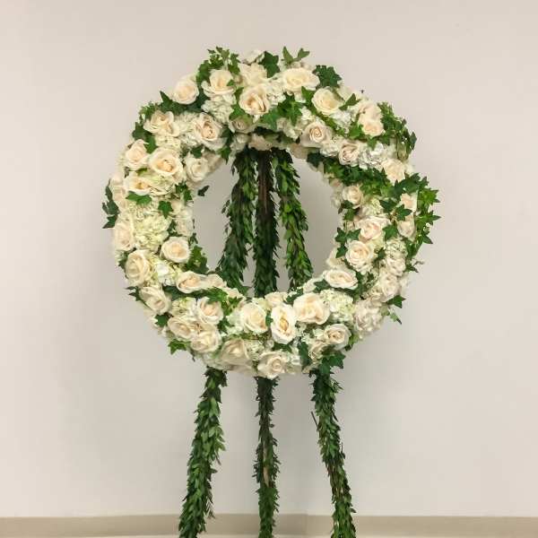 White rose funeral wreath on a standing easel