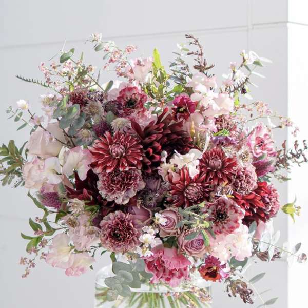 Large pink and burgundy bouquet in a clear glass vase