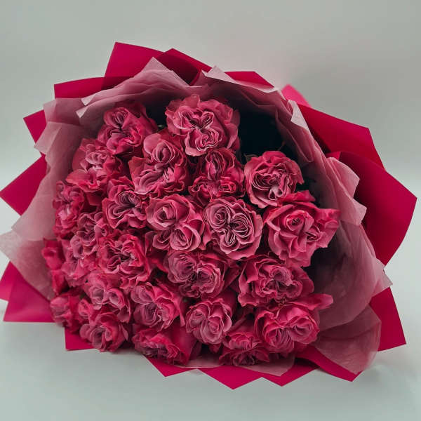 Bouquet of pink roses wrapped in pink paper