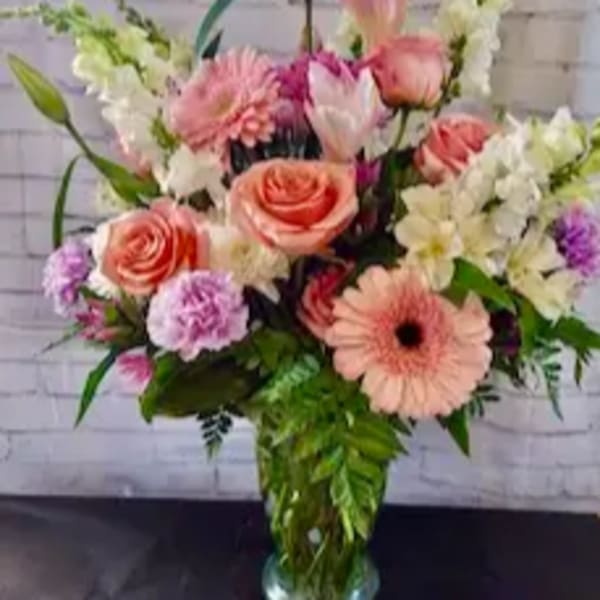Pink and white mixed flower arrangement in a glass vase