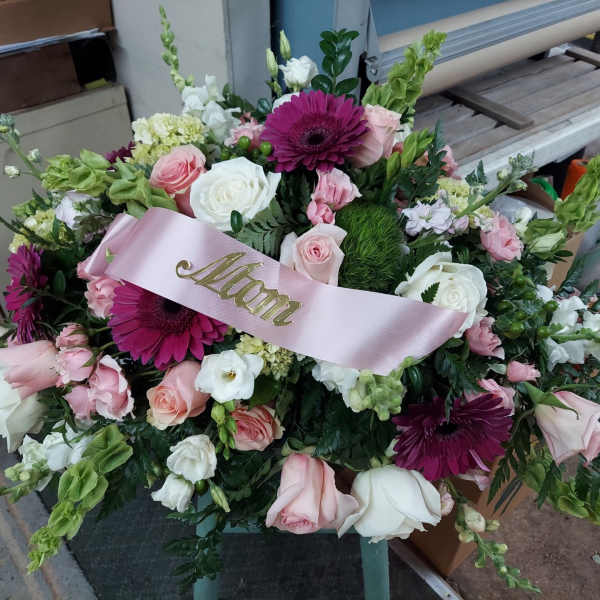 Pink and white rose bouquet with magenta daisies and a pink ribbon labeled Mom