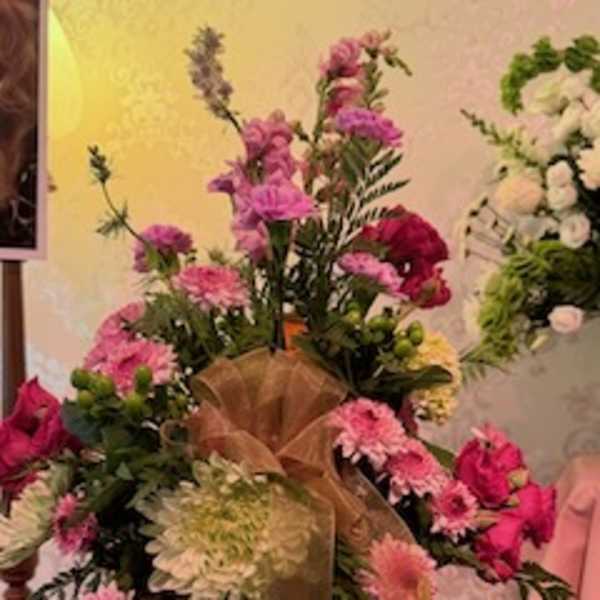 Basket arrangement of pink and white flowers with a ribbon