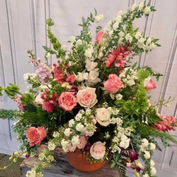 Large pink and white floral arrangement in a terracotta pot