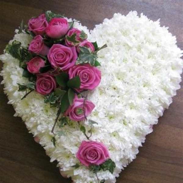 Heart-shaped white floral arrangement with pink roses