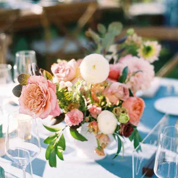 Pink and white floral centerpiece with candles on a table