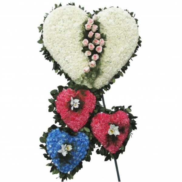 Heart-shaped floral tribute with white, pink, red, and blue blooms
