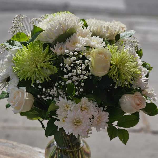 White and pale green bouquet in a glass vase