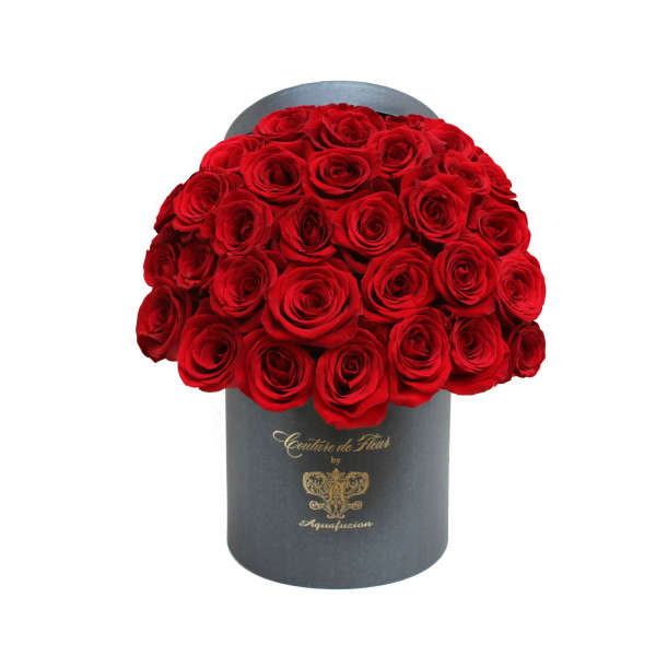 Red roses arranged in a black cylindrical box