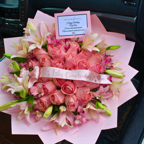 Pink rose bouquet with lilies and a birthday card in a car seat