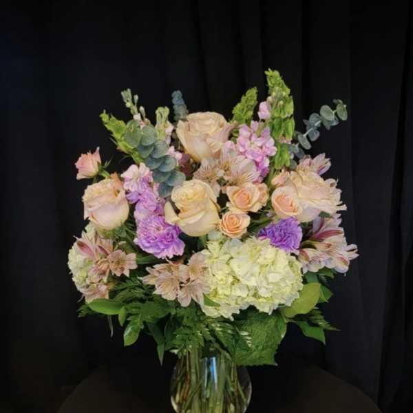 Pastel bouquet of roses, hydrangea, and alstroemeria in a glass vase