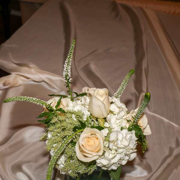 Cream roses and white hydrangeas in a square glass vase