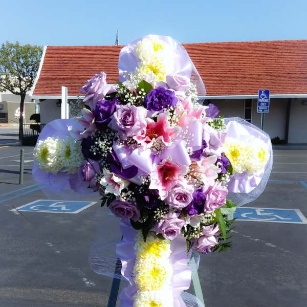 Large purple and white floral cross on a stand