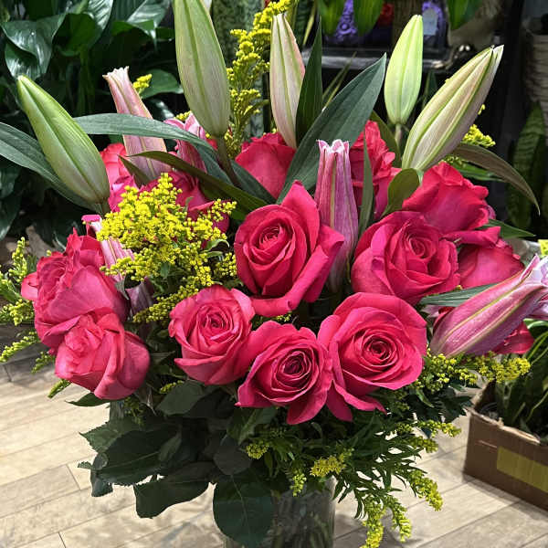 Pink roses and unopened lilies in a glass vase