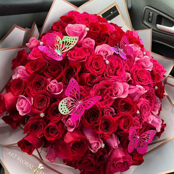 Large bouquet of red and pink roses with butterfly decorations