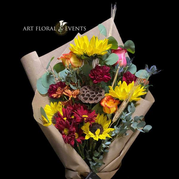 Bouquet of yellow sunflowers and red roses wrapped in brown paper
