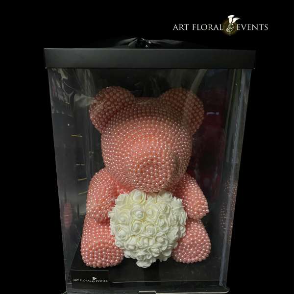 Pink pearl teddy bear holding a white rose heart in a display box
