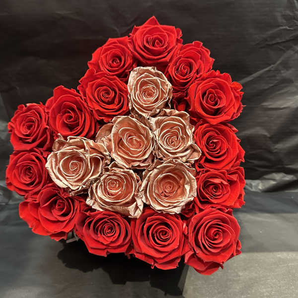 Round bouquet of red and gold roses on a dark background