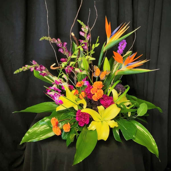 Tropical floral arrangement with orchids, lilies, and bird of paradise