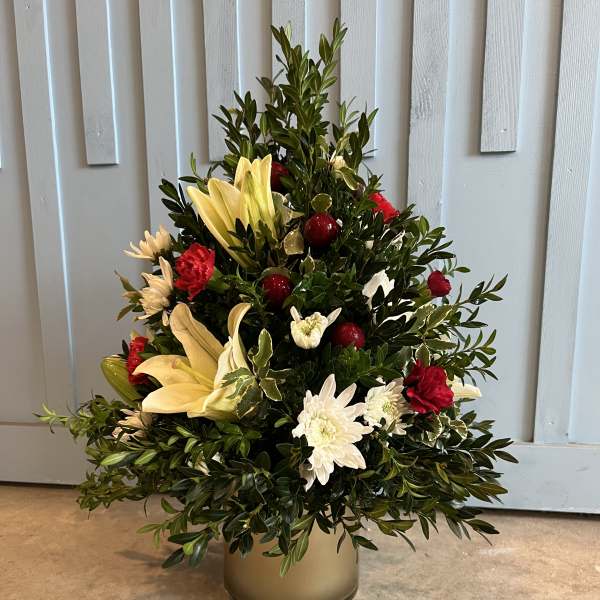 Mixed floral arrangement in a gold vase with lilies, chrysanthemums, and red accents