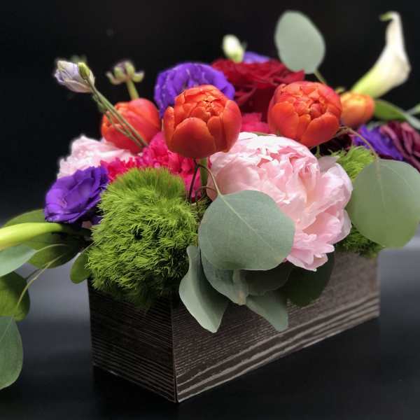 Colorful mixed flower arrangement in a rectangular box with calla lilies