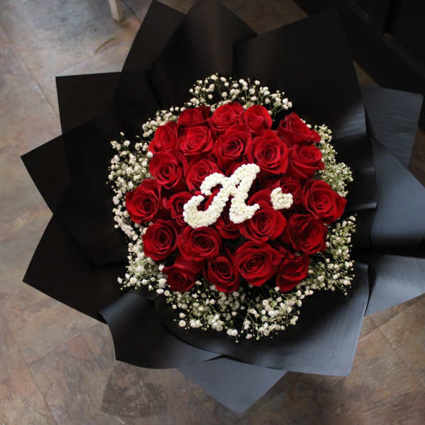 Bouquet of red roses with white baby's breath and a white monogram