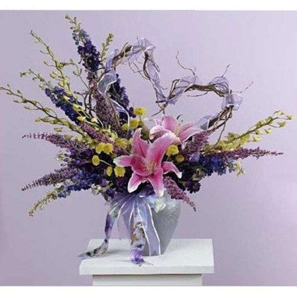 Pink lilies in a silver vase with purple and yellow flowers
