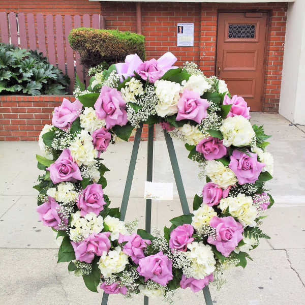 Pink and white floral wreath on a stand