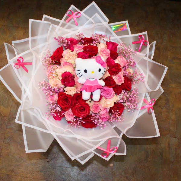 Bouquet of red and pink roses with a Hello Kitty plush in white wrapping