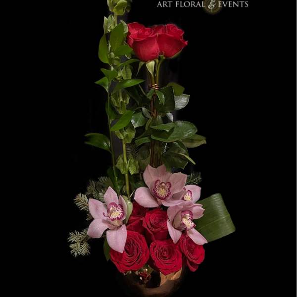 Tall floral arrangement with red roses and pink orchids in a vase
