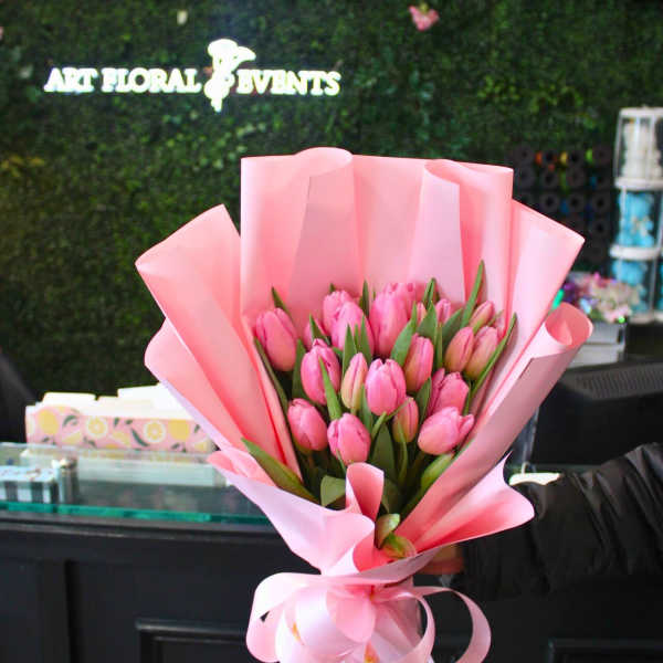 Pink tulip bouquet wrapped in pastel pink paper with a ribbon