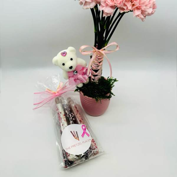 Pink carnation arrangement in a pot with a teddy bear and wrapped pretzels