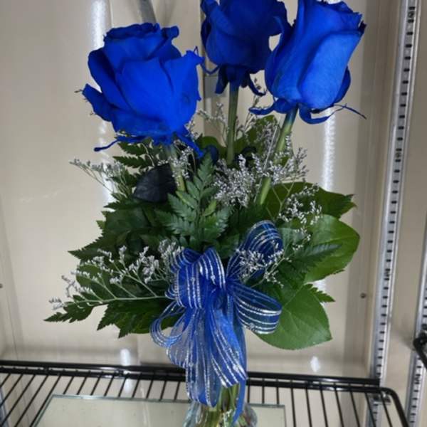 Bouquet of blue roses with a ribbon in a clear vase