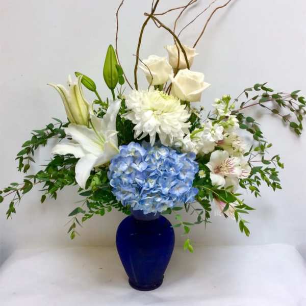 Blue and white floral arrangement in a cobalt vase