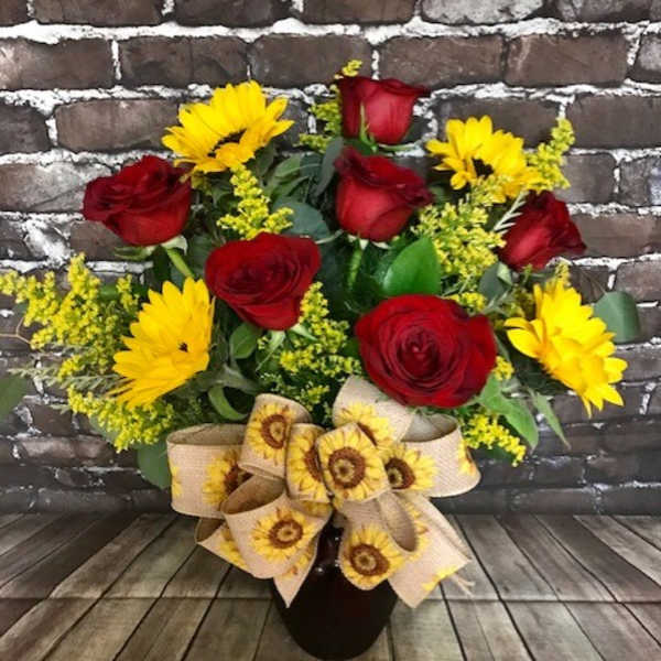 Bouquet of red roses and yellow daisies in a black vase with a sunflower ribbon